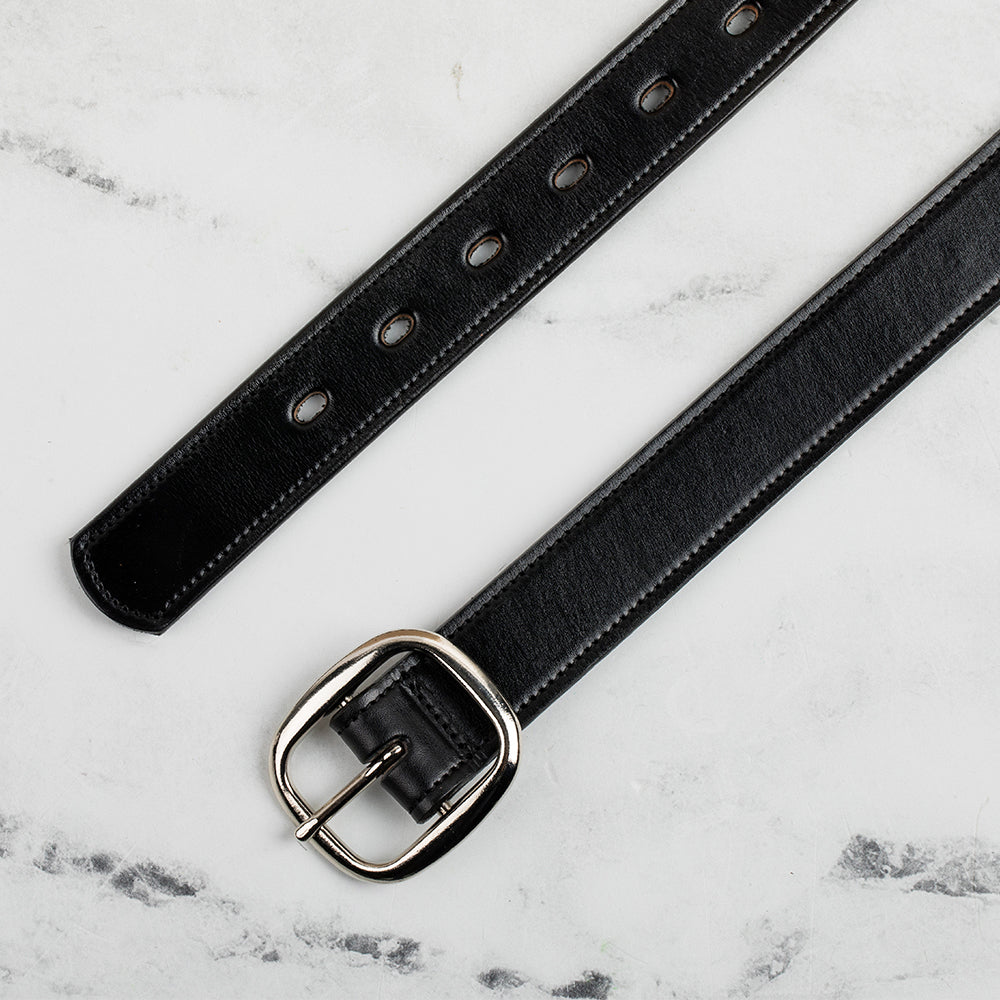 A laid-flat Eloise Belt - 1.25&quot; by Hanks Belts, crafted in premium black vegetable-tanned leather with a silver center bar buckle, features multiple adjustment holes on a white marble surface.