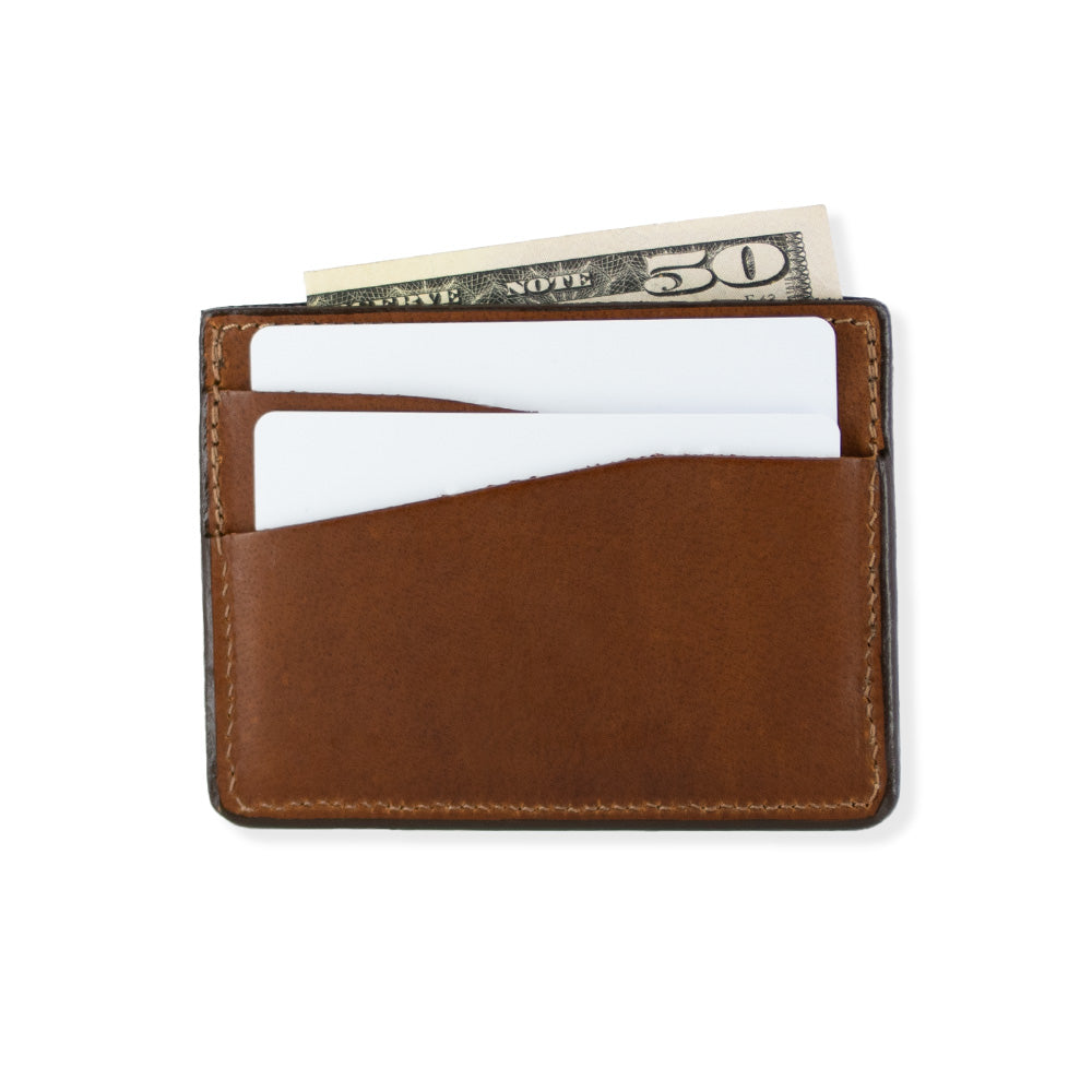 The Cumberland Bison Card Holder in peanut brown by Hanks Belts, a durable wallet made from premium bison leather, showcases two white cards and a partially visible $50 bill peeking out of the top pocket, isolated on a white background.