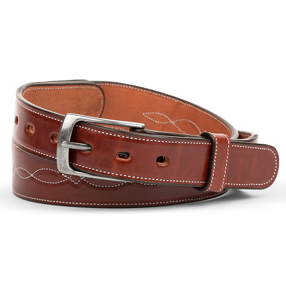 Introducing Hanks Belts&#39; The Teton - 1.5&quot;, a handcrafted masterpiece in brown Premium English Bridle Vegetable Tanned Leather, featuring a silver buckle, white stitching, decorative loop patterns, and a lighter brown interior.