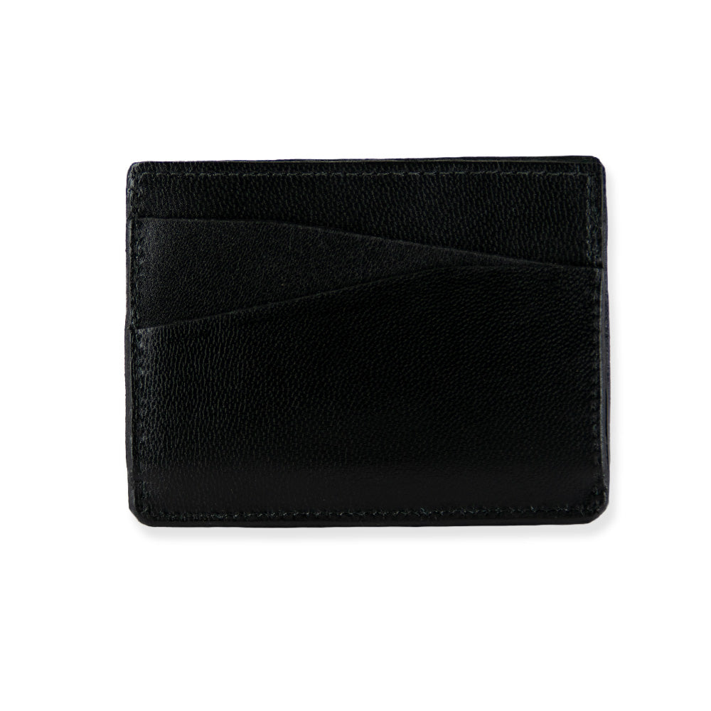 The Monroe Goatskin Card Holder by Hanks is a sleek, black goatskin leather cardholder with a minimalist design featuring two diagonal card slots on the front. The textured leather provides a sophisticated and refined look against a plain white background, while its slim profile ensures convenience without sacrificing style.