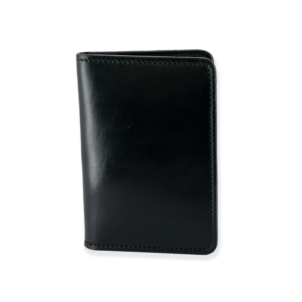 The Superior Front Pocket Bifold by Hanks Belts is a sleek black leather passport holder, handcrafted from premium harness leather. It features a smooth texture with visible edge stitching and is proudly made in the USA, shown upright and closed against a plain white background.