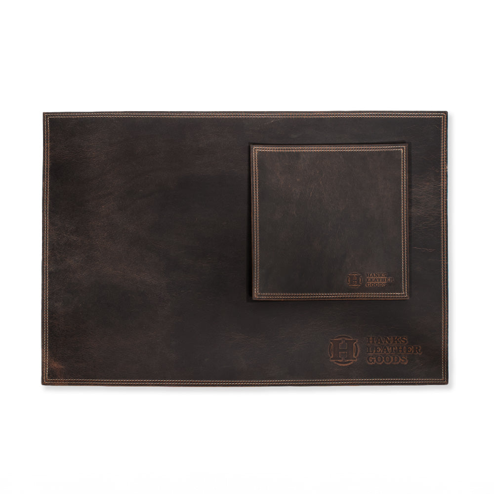 A brown Desk &amp; Mouse Pad Set paired with a matching coaster, crafted from North American Bison Leather and embossed with the &quot;Hanks Belts&quot; logo at the bottom corner. Handmade in the USA, this set exudes a rustic, worn-in charm.