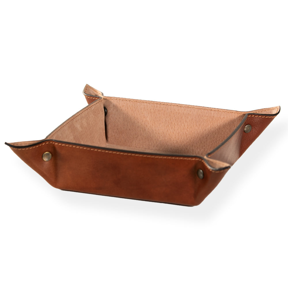 The Italian Large Valet Tray by Hanks Belts is showcased in a photo, exhibiting its square design and travel-ready functionality. Made of full-grain brown leather with sleek metal button snaps at the corners, it boasts a soft suede-like interior and is placed against a pristine white background.