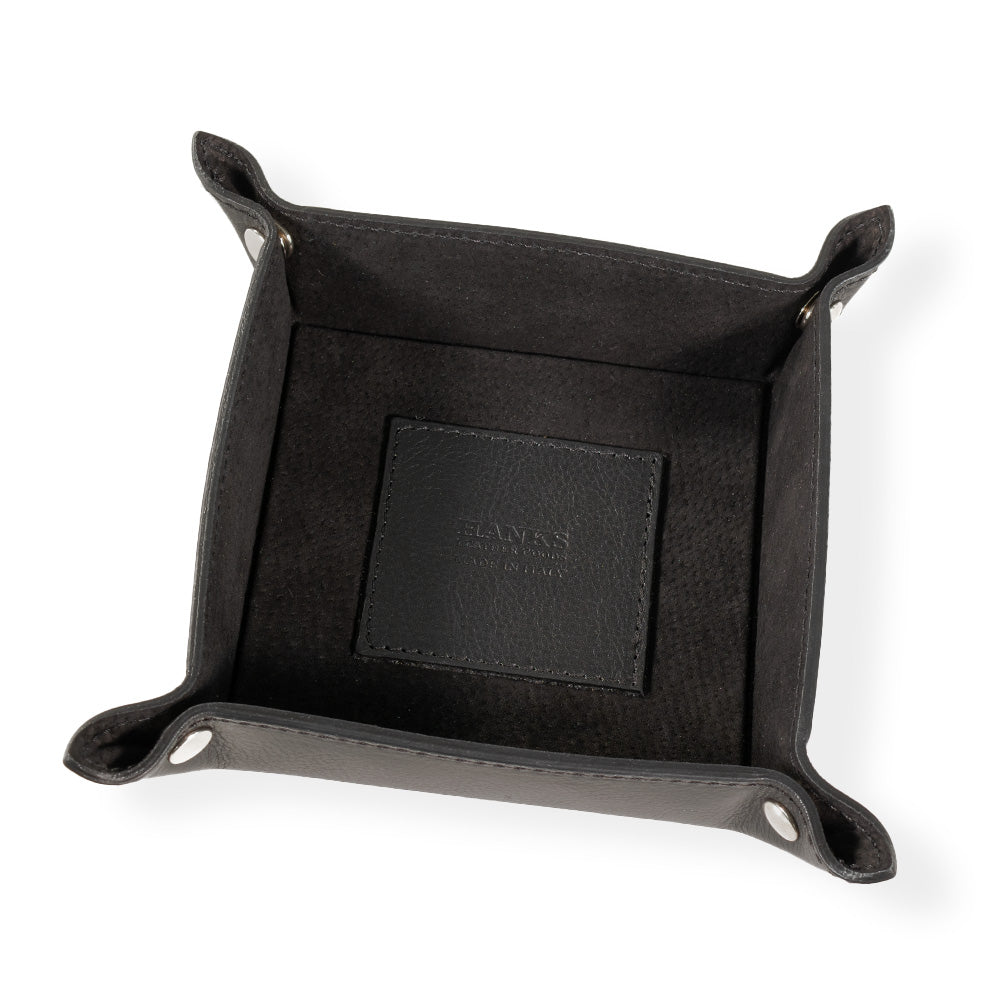 The Italian Compact Valet Tray by Hanks Belts is crafted from square black Italian leather, featuring a compact design with raised edges and snap buttons at the corners. A stitched square leather patch is positioned at the center of this travel-friendly tray.