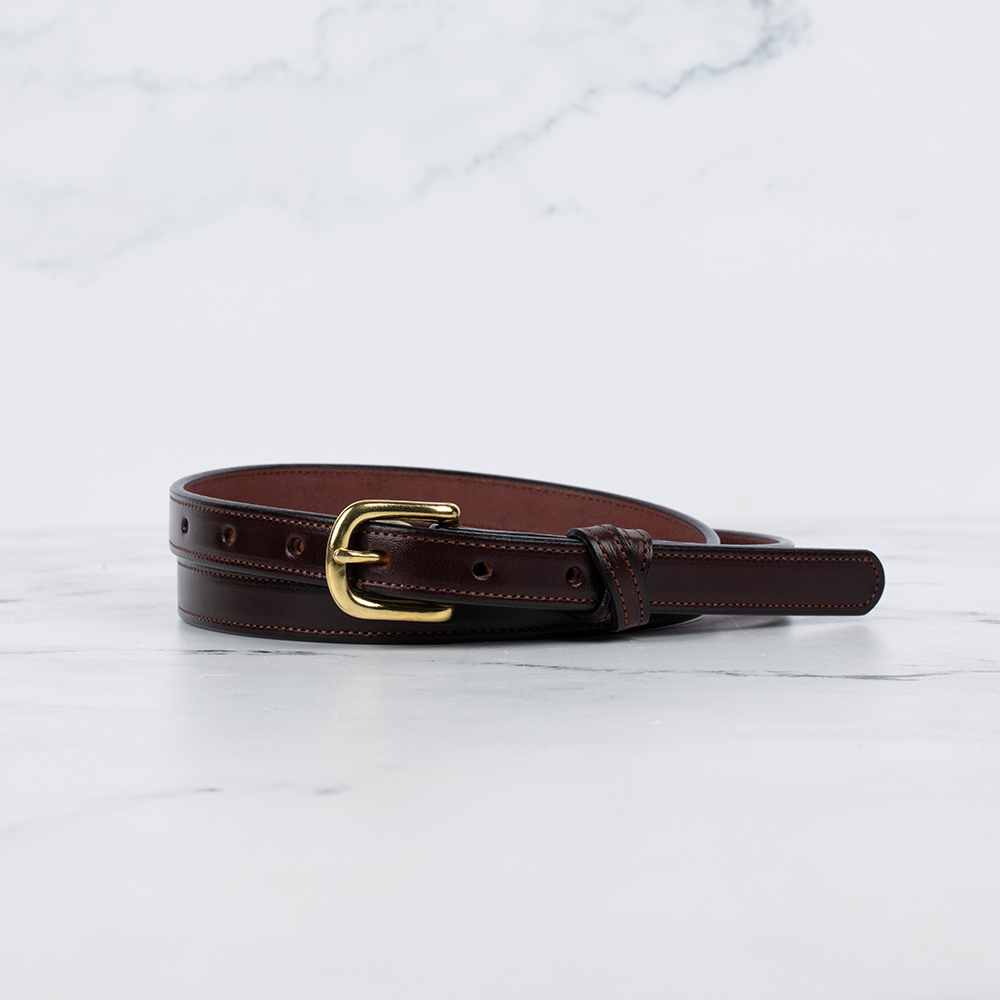 The Hanks Belts Dixie Belt - .75&quot; features Premium English Bridle Leather in rich havana, with a gold buckle elegantly set against a marble surface, highlighting exquisite American craftsmanship.