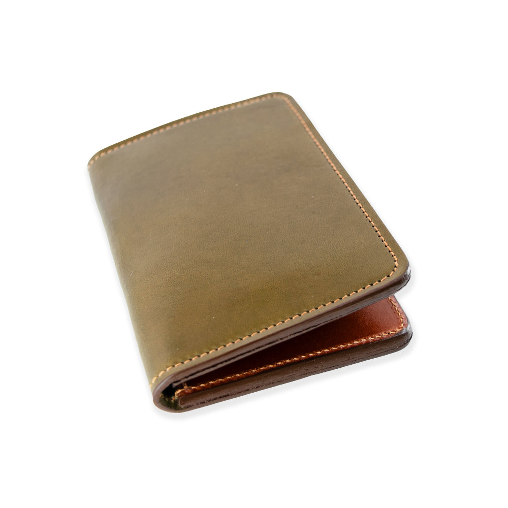 The Hanks Belts Superior Front Pocket Bifold, crafted from premium harness leather, features a smooth brown exterior with a darker brown interior. Its artisanal elegance is displayed diagonally against a plain white background.