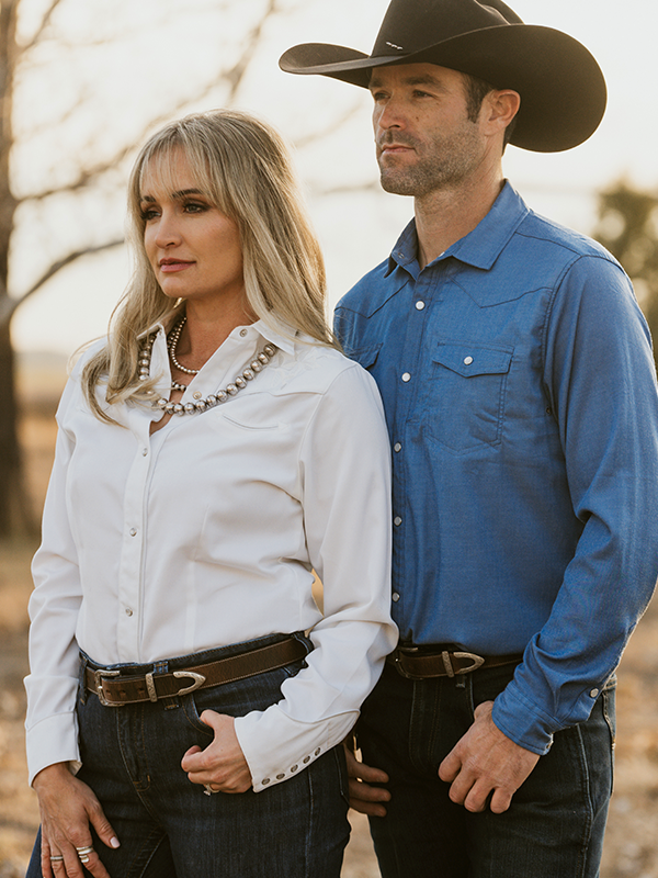 Man and woman standing together wearing hanks belts in a grassy field